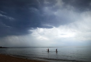 Couple under clouds in the water at Brighton Beach